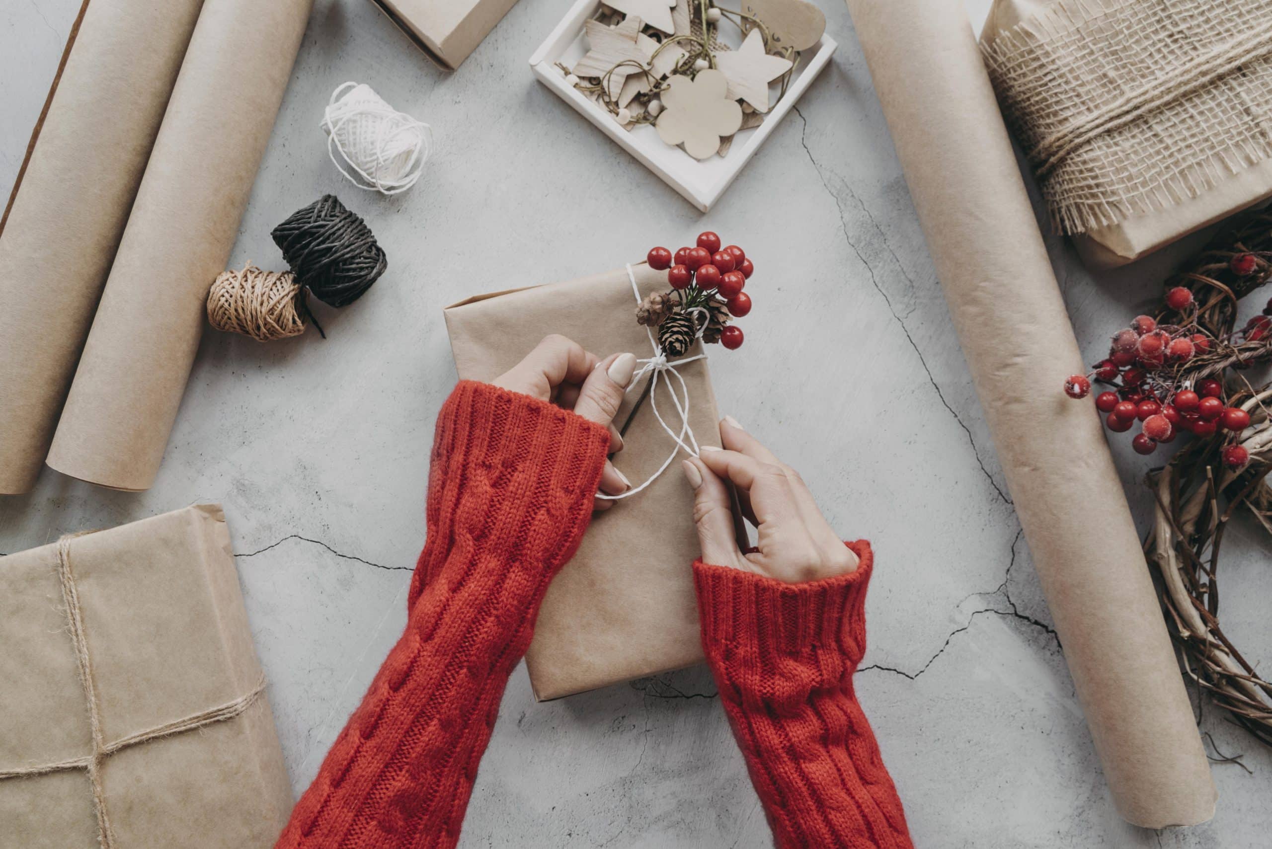 gros plan sur des mains en train d’emballer des cadeaux avec soin